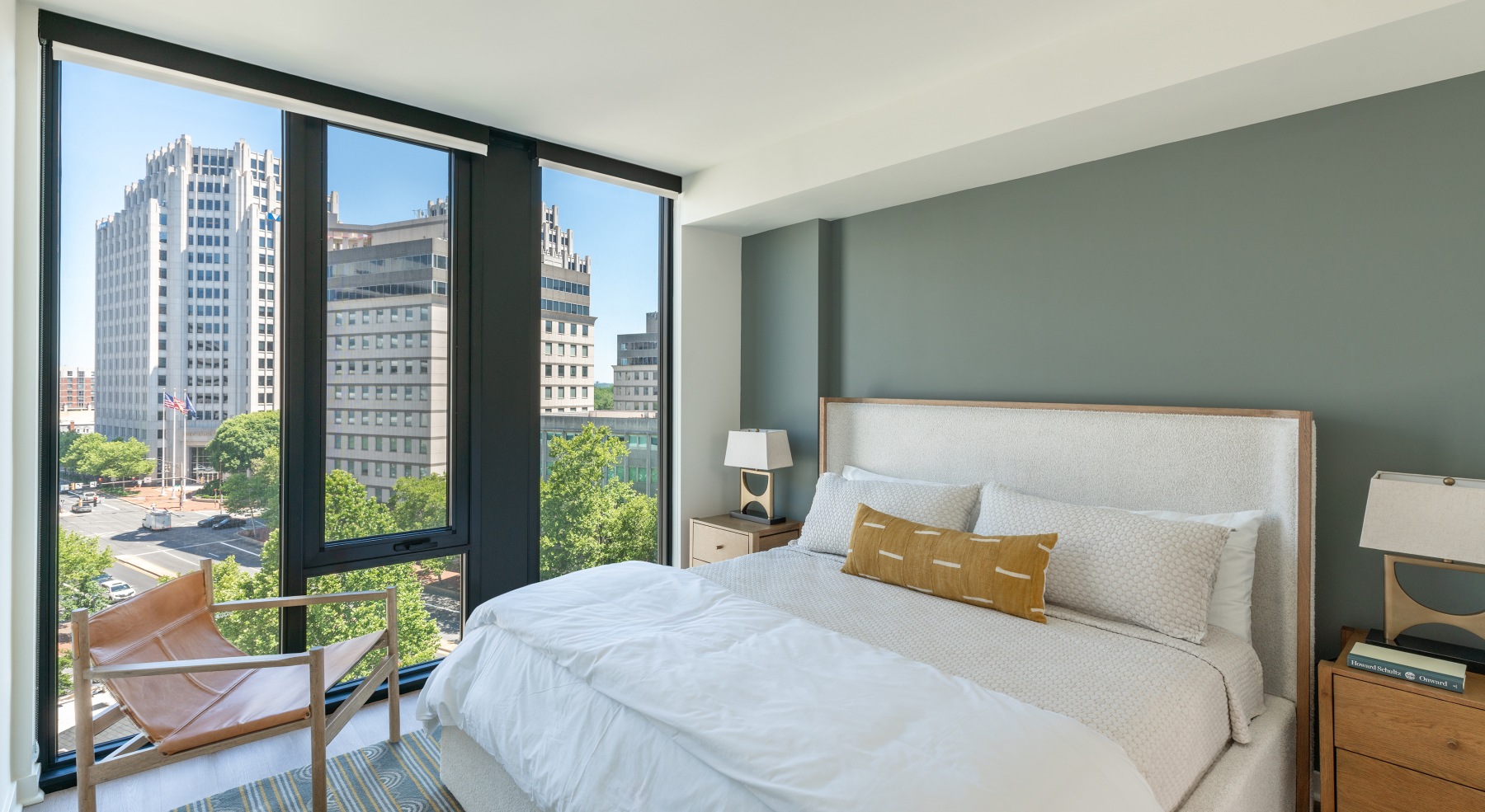 a bedroom with a bed and two nightstands and windows